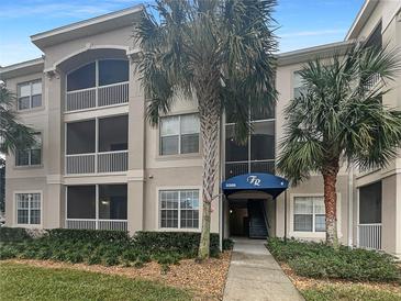 Exterior view of a three-story condo building with palm trees and landscaping at 3300 Whitestone Cir # 101, Kissimmee, FL 34741