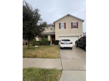 Two-story house with attached garage and a well-maintained lawn at 3666 Maidencain St, Clermont, FL 34714