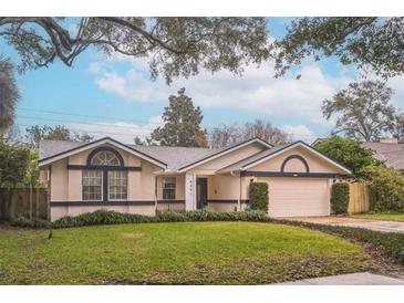 Single-story home with attached garage, well-manicured lawn, and mature trees at 4491 Yachtmans Ct, Orlando, FL 32812