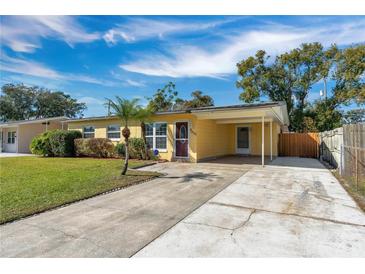 Bright yellow house with carport and well-maintained lawn at 4806 Hollyberry Dr, Orlando, FL 32812