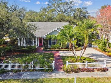 Aerial view of a charming house with a well-manicured lawn and a brick driveway at 506 N Dillard St, Winter Garden, FL 34787