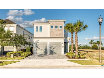 Two-story house with gray siding, stone accents, and a two-car garage at 801 Golden Bear Dr, Kissimmee, FL 34747