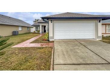 House exterior showcasing a two-car garage and well-maintained lawn at 8813 Parliament Ct, Kissimmee, FL 34747