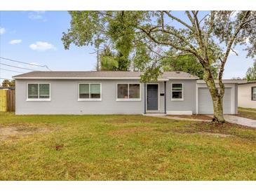 Newly renovated single-story home with gray exterior, landscaping, and driveway at 107 Japonica Dr, Orlando, FL 32807