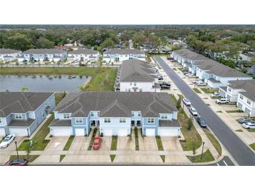 Aerial view of townhouses with garages and a lake nearby at 2719 Bright Bird Ln, Winter Park, FL 32792