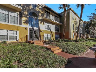 Building exterior with landscaping and palm trees at 4017 Versailles Dr # 4017F, Orlando, FL 32808