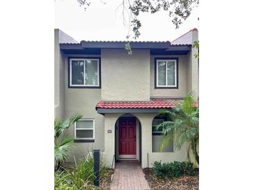 Inviting two-story townhome with red door and landscaping at 1007 Baseball And Boardwalk Ct, Kissimmee, FL 34746