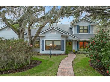 Two-story house with blue siding, brick pathway, and lush landscaping at 1105 Superior Ct, Winter Springs, FL 32708