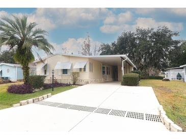 Single-wide manufactured home with carport and landscaped yard at 214 Covent Garden Ave, Davenport, FL 33897