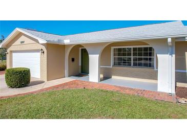 Inviting front porch with an arched entryway and a well-maintained lawn at 2207 Winter Woods Blvd, Winter Park, FL 32792