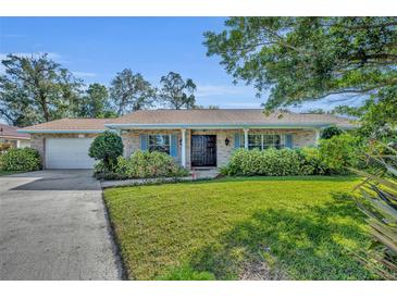 Charming single-story home featuring a brick facade, well-manicured lawn, and double door entry at 4130 Floralwood Ct, Orlando, FL 32812