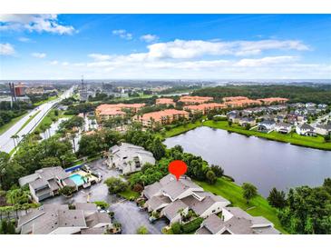 Aerial view of a condo community near a lake, showing the subject property at 5381 Vineland Rd # S, Orlando, FL 32811