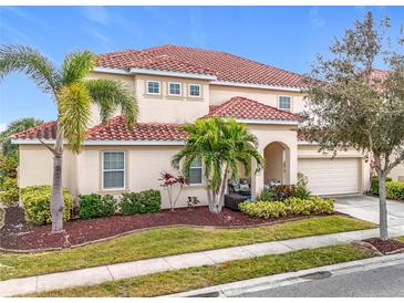 Two-story house with tile roof, landscaping, and a two-car garage at 6156 Broad Oak Dr, Davenport, FL 33837