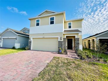 Two-story house with a two-car garage and a brick paved driveway at 6976 Church Lake St, Groveland, FL 34736