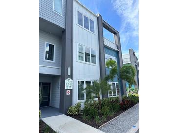 Modern building exterior with gray and blue accents, landscaping, and walkway at 7770 Sandy Ridge Dr # 126, Reunion, FL 34747