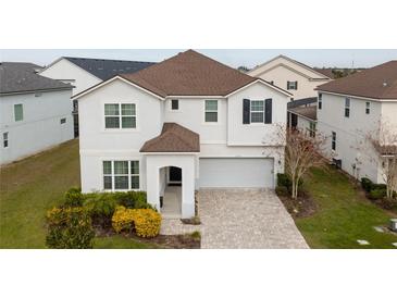 Two-story house with a white exterior, brown roof, and a paved driveway at 8953 Hilton Ridge Ave, Kissimmee, FL 34747