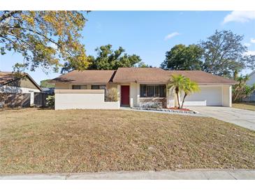 Single-story house with brown roof, red door, and landscaped front yard at 1163 Queen Elaine Dr, Casselberry, FL 32707