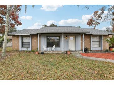 Brick ranch home with gray roof, landscaping, and covered porch at 1510 Chatsworth Ave, Deltona, FL 32738