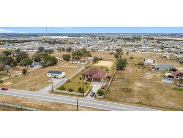 Aerial view of a house with surrounding land and other houses at 1719 North W Blvd, Davenport, FL 33837