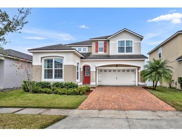 Two-story house with red door and brick driveway at 2516 Nouveau Way, Kissimmee, FL 34741