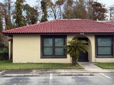 Front view of charming condo with red tile roof and landscaping at 532 Hunter Cir, Kissimmee, FL 34758