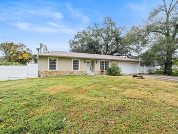 Ranch style home with a well-maintained lawn and a white picket fence at 1018 Bear Lake Rd, Apopka, FL 32703