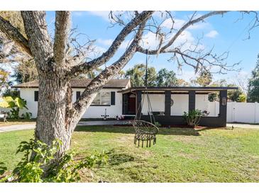 Charming ranch home with a covered porch and well-manicured lawn at 117 Temple St, Deland, FL 32720