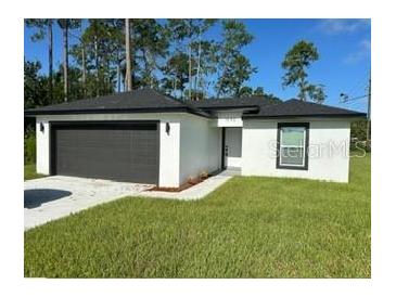 Newly constructed home with a two-car garage and well-manicured lawn at 1590 West Pkwy, Deland, FL 32724