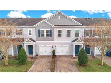 Two-story townhouses with gray siding, blue doors, and paved driveways at 190 Mitchell Creek Way, Oviedo, FL 32765