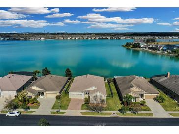 Stunning aerial view of waterfront homes on a sunny day with blue skies and calm lake at 219 Blue Cypress Dr, Groveland, FL 34736