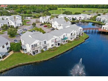 Aerial view of waterfront condos with parking and a fountain at 2512 Woodgate Blvd # 105, Orlando, FL 32822