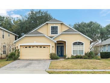 Charming yellow two-story home with a well-manicured lawn and attached two-car garage at 33925 Terragona Dr, Sorrento, FL 32776