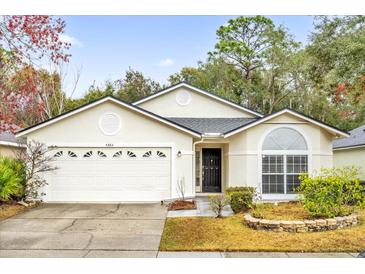 Single-story house with attached garage and landscaped yard at 4382 Weeping Willow Cir, Casselberry, FL 32707