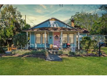 Charming bungalow with a pink door, front porch, and well-maintained lawn at 549 Glenway Dr, Sanford, FL 32771