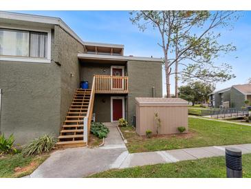 Exterior view of condo with stairs, private entrance, and storage unit at 5896 Peregrine Ave # C01, Orlando, FL 32819