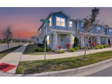 Two-story townhome with light blue siding, landscaping, and a welcoming front porch at 609 Bayhawk St, Debary, FL 32713