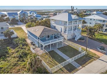 Two-story home with fenced yard, elevated decks, and waterfront views at 6912 S Atlantic Ave, New Smyrna Beach, FL 32169