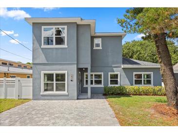 Two-story home with a modern gray facade, white window trim, and a paved driveway, offering curb appeal at 1875 Staunton Ave, Winter Park, FL 32789