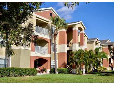 Three-story apartment building with light colored walls and balconies at 1950 Summer Club Dr # 302, Oviedo, FL 32765