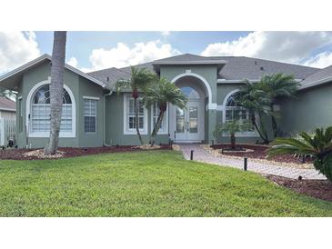 Green house exterior with palm trees and landscaped yard at 4726 Combahee Ln, Orlando, FL 32837