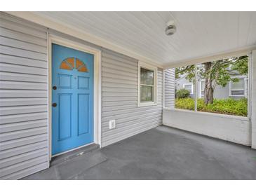 Inviting front porch with blue door and screened enclosure at 747 Mcintyre Ave, Winter Park, FL 32789
