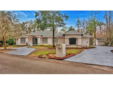 Attractive single-story home with landscaped yard and circular driveway at 2397 River Tree Cir, Sanford, FL 32771