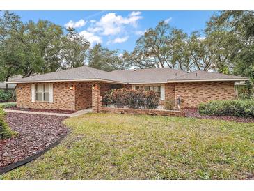 Brick ranch house with landscaped yard and shed at 9908 Fairway Cir, Leesburg, FL 34788