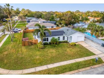 Beautiful home with a manicured lawn, solar panels, and a fenced backyard, offering both style and energy efficiency at 102 Aberdeen Dr, Fern Park, FL 32730