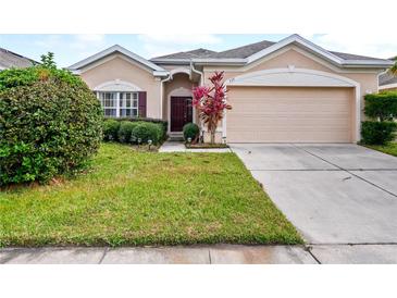 Tan house with a two-car garage and manicured lawn at 337 Fern Lake Dr, Orlando, FL 32825