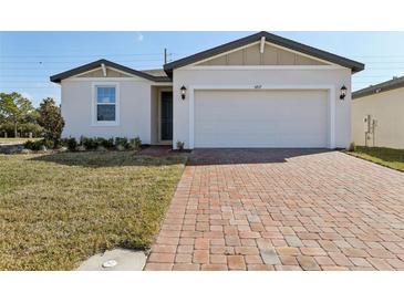 Charming single-story home featuring a brick driveway, manicured lawn, and a two-car garage at 4537 Sidesaddle Trl, St Cloud, FL 34772