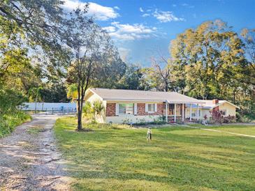 Ranch-style home with mature landscaping and a spacious yard at 5240 N Powers Dr, Orlando, FL 32818