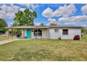 Cute ranch home with turquoise door, carport, and well-manicured lawn at 544 Eartha Ln, Orlando, FL 32805