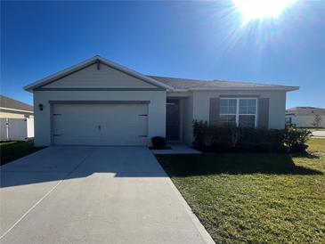 Single-story house with a two-car garage and well-manicured lawn at 617 Finn Ave, Auburndale, FL 33823