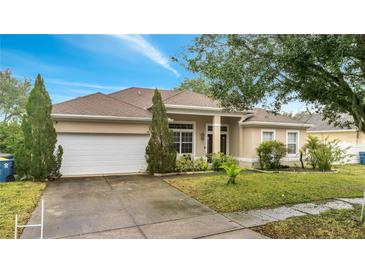 Attractive single-story home with a two-car garage and well-manicured lawn at 116 Whispering Pines Way, Davenport, FL 33837